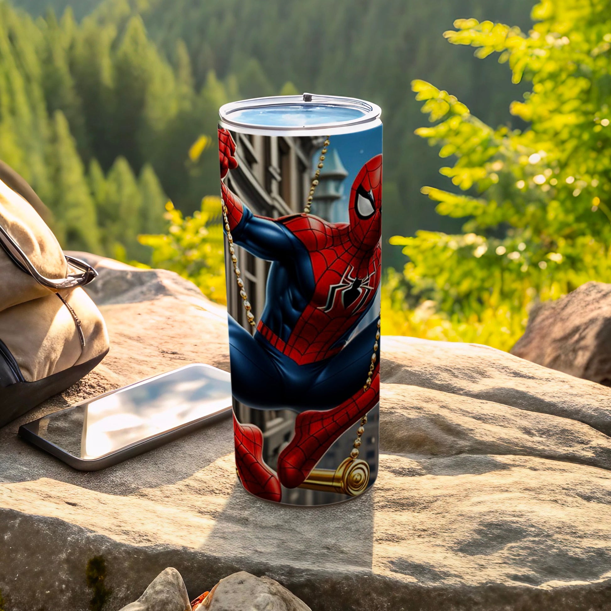 Spiderman tumbler hanging on a golden web outdoors with a backpack and phone.