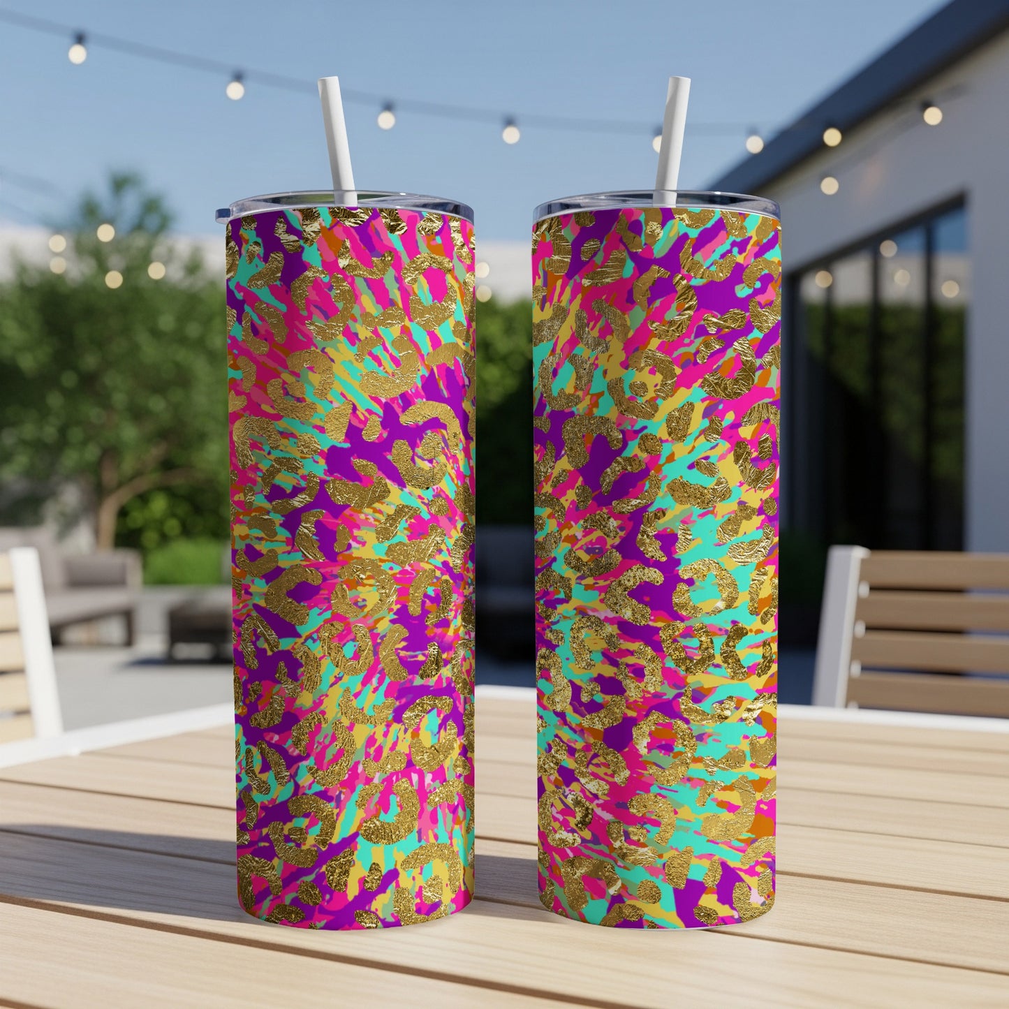 Two tall tumblers with a colorful leopard print and gold accents on a table.