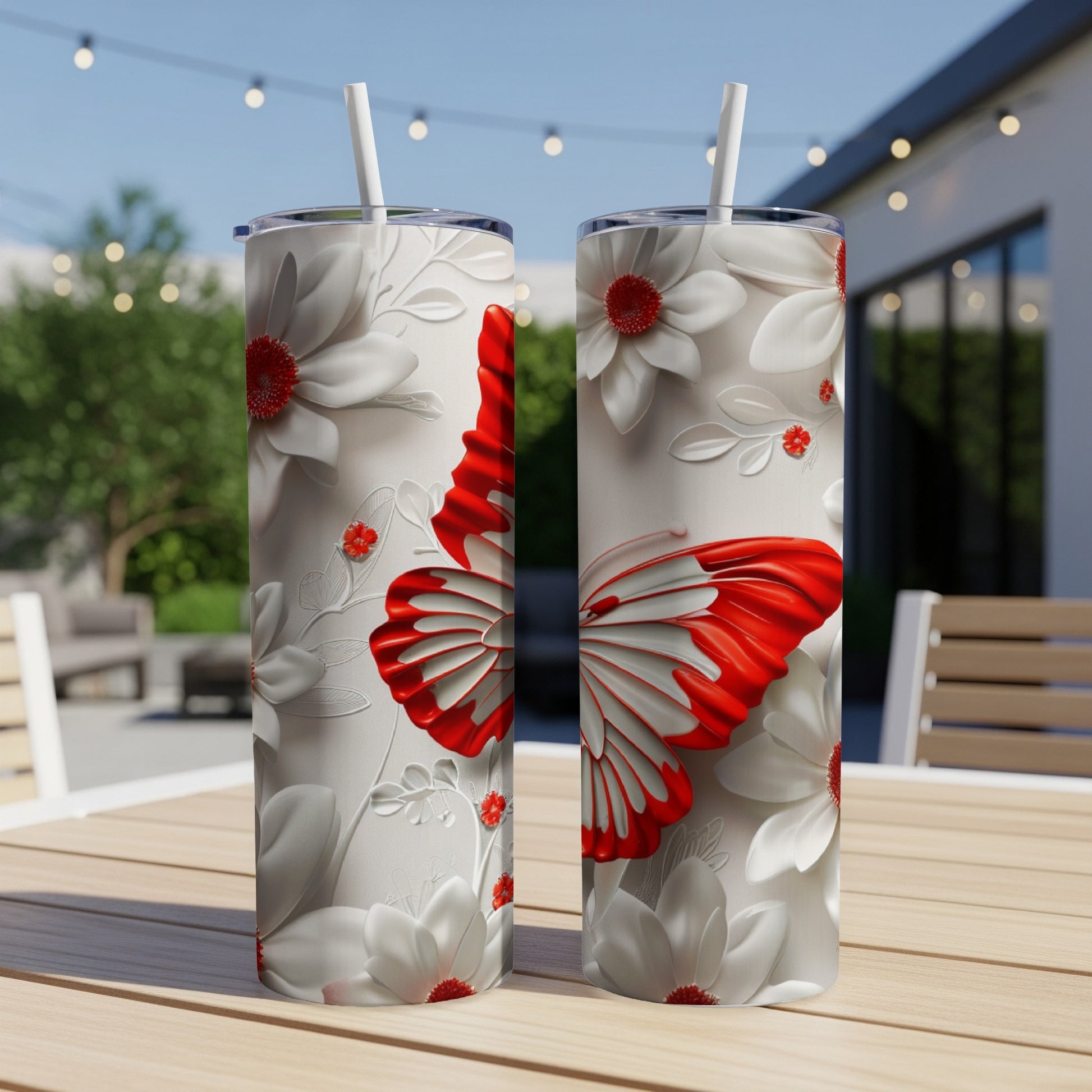 Two white tumblers with red butterfly and floral designs on a wooden table.