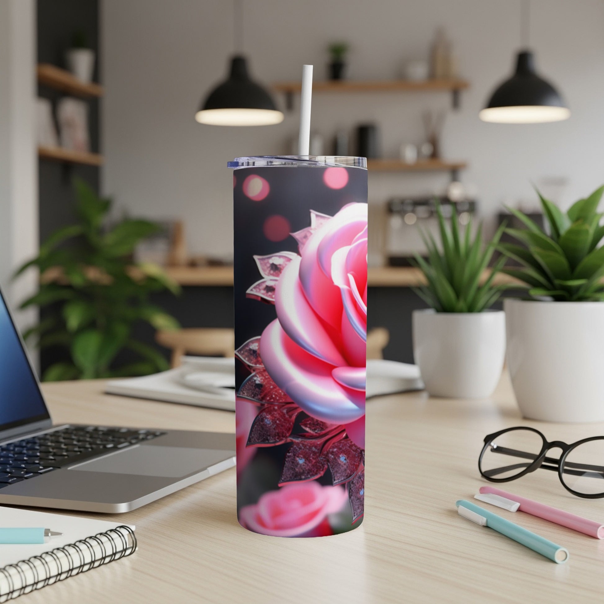 Tumbler with a pink rose design and sparkles, on a desk.