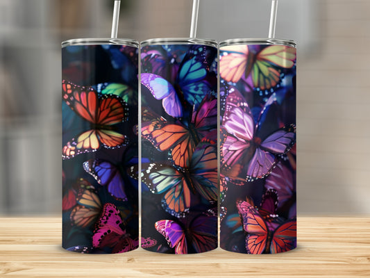 Three tumblers with colorful butterfly designs, displayed on a wooden surface.