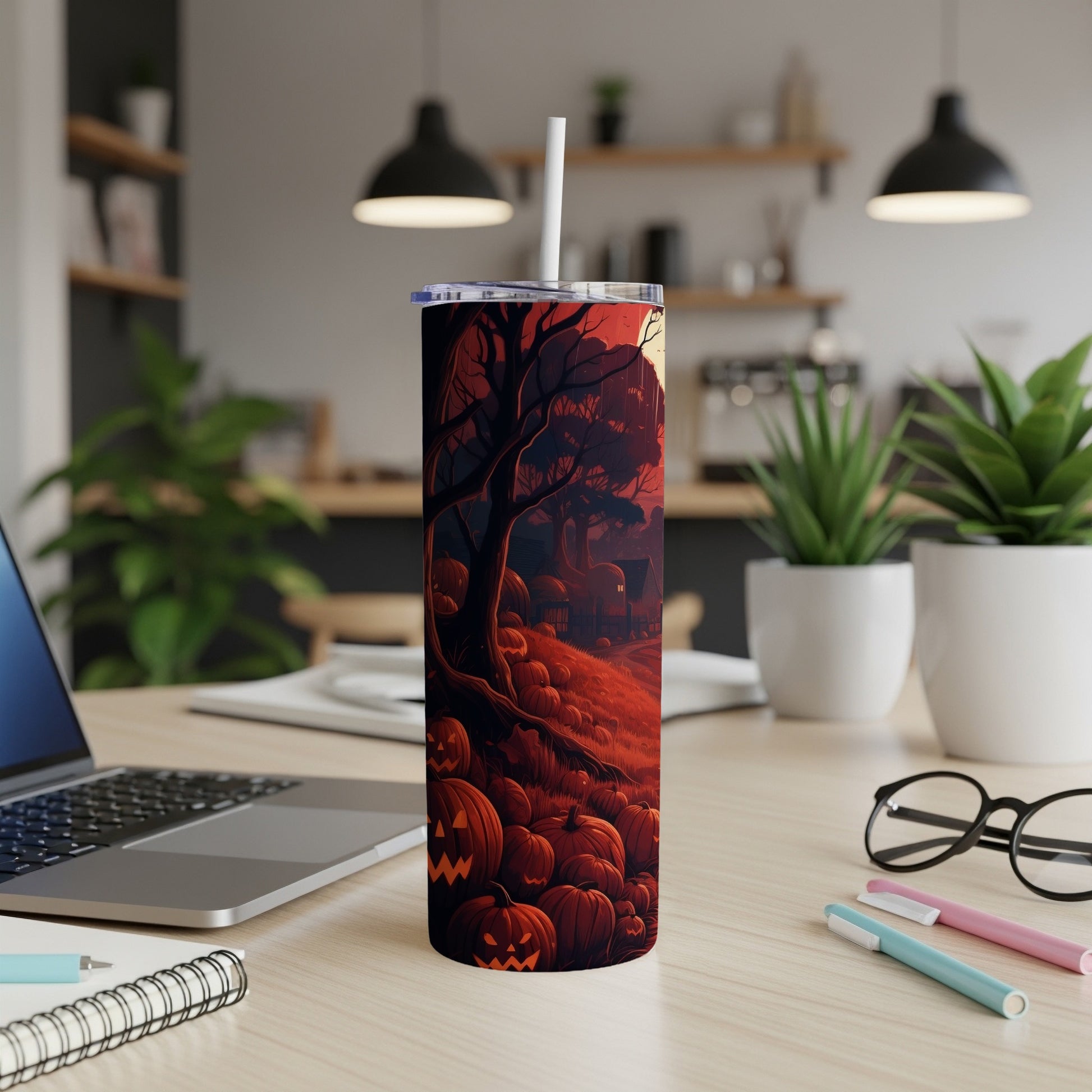Tumbler with a Halloween scene featuring pumpkins and a bare tree under a red sky.