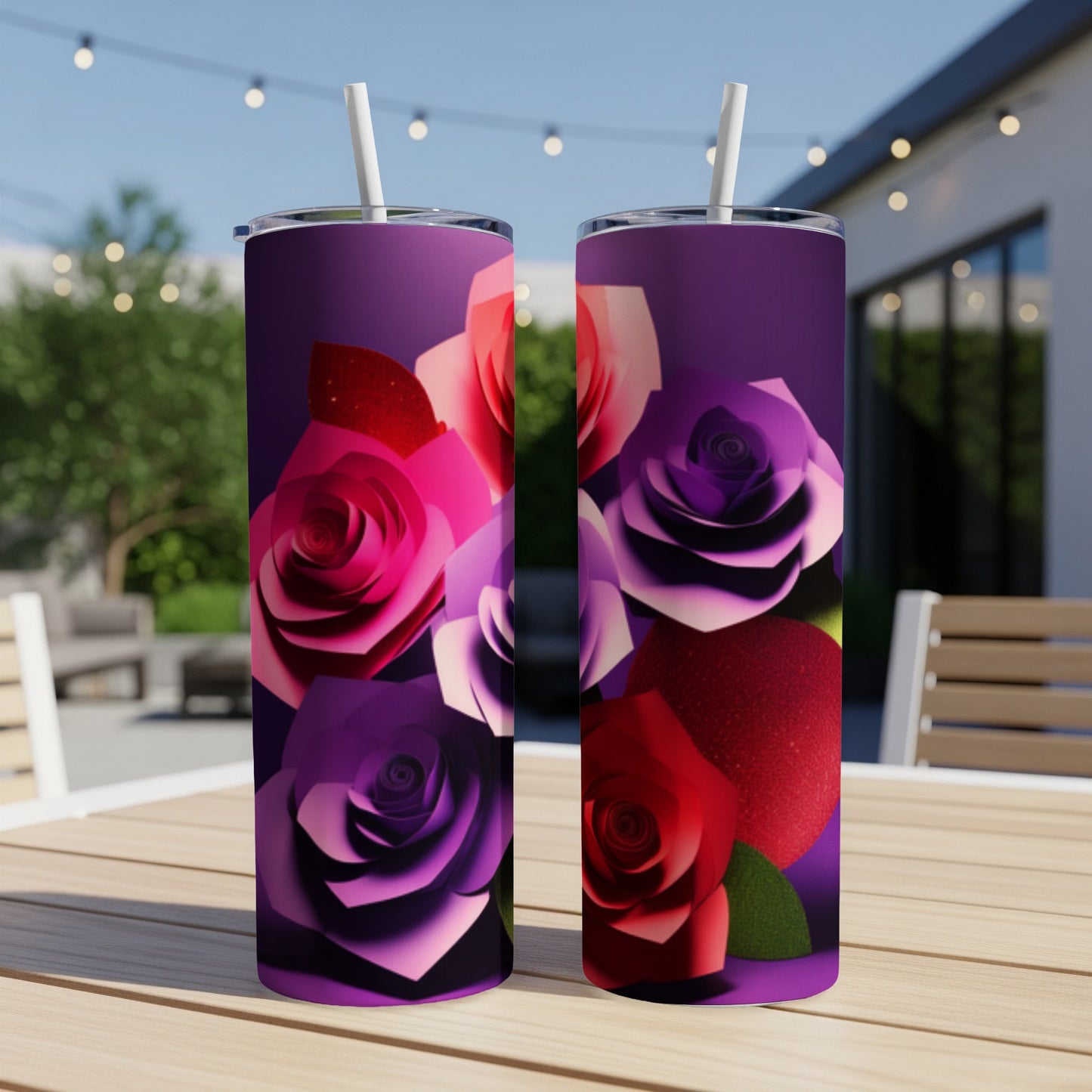 Two purple and pink rose-decorated tumblers with straws on a table.