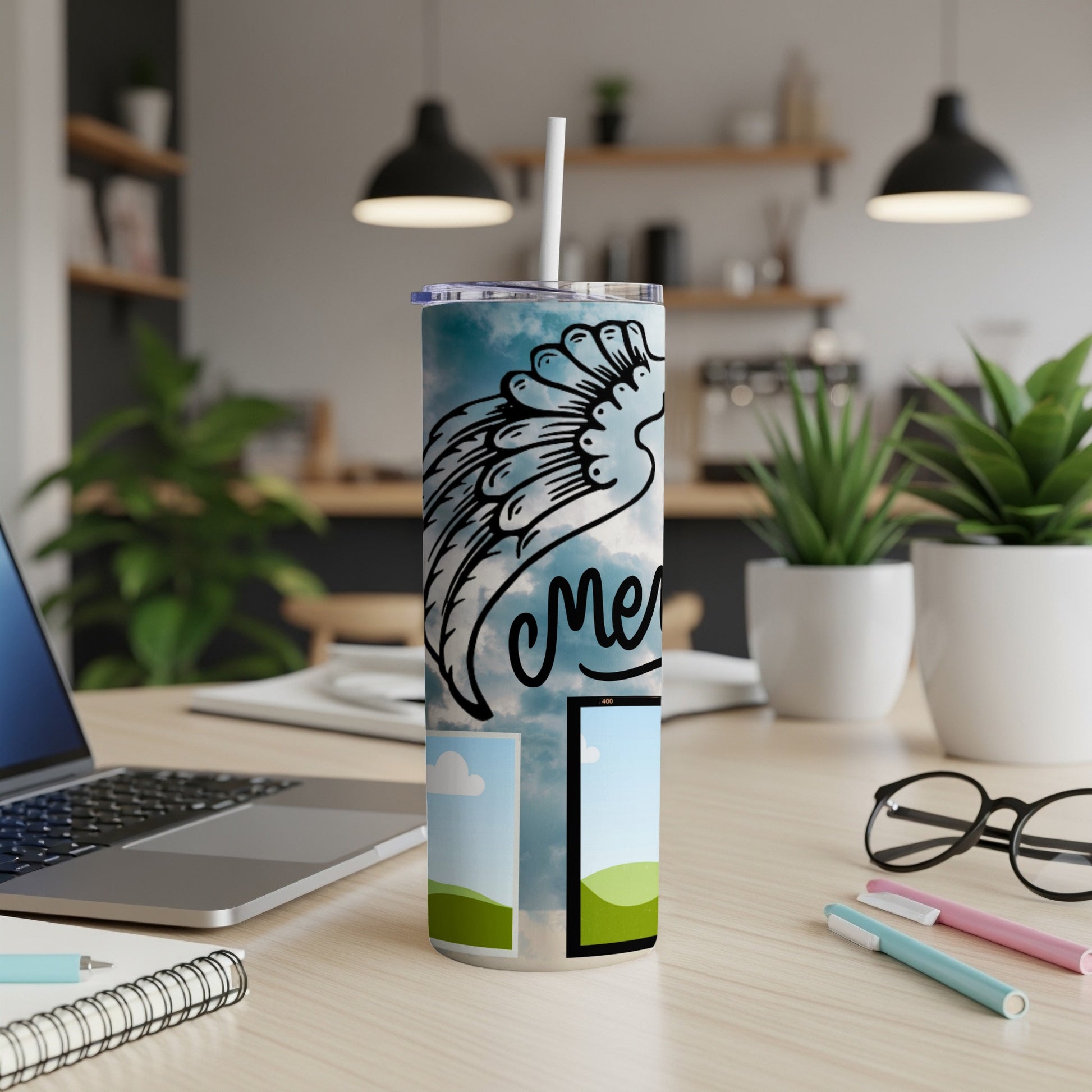 Tumbler with angel wing design and "mercy" text on a desk.