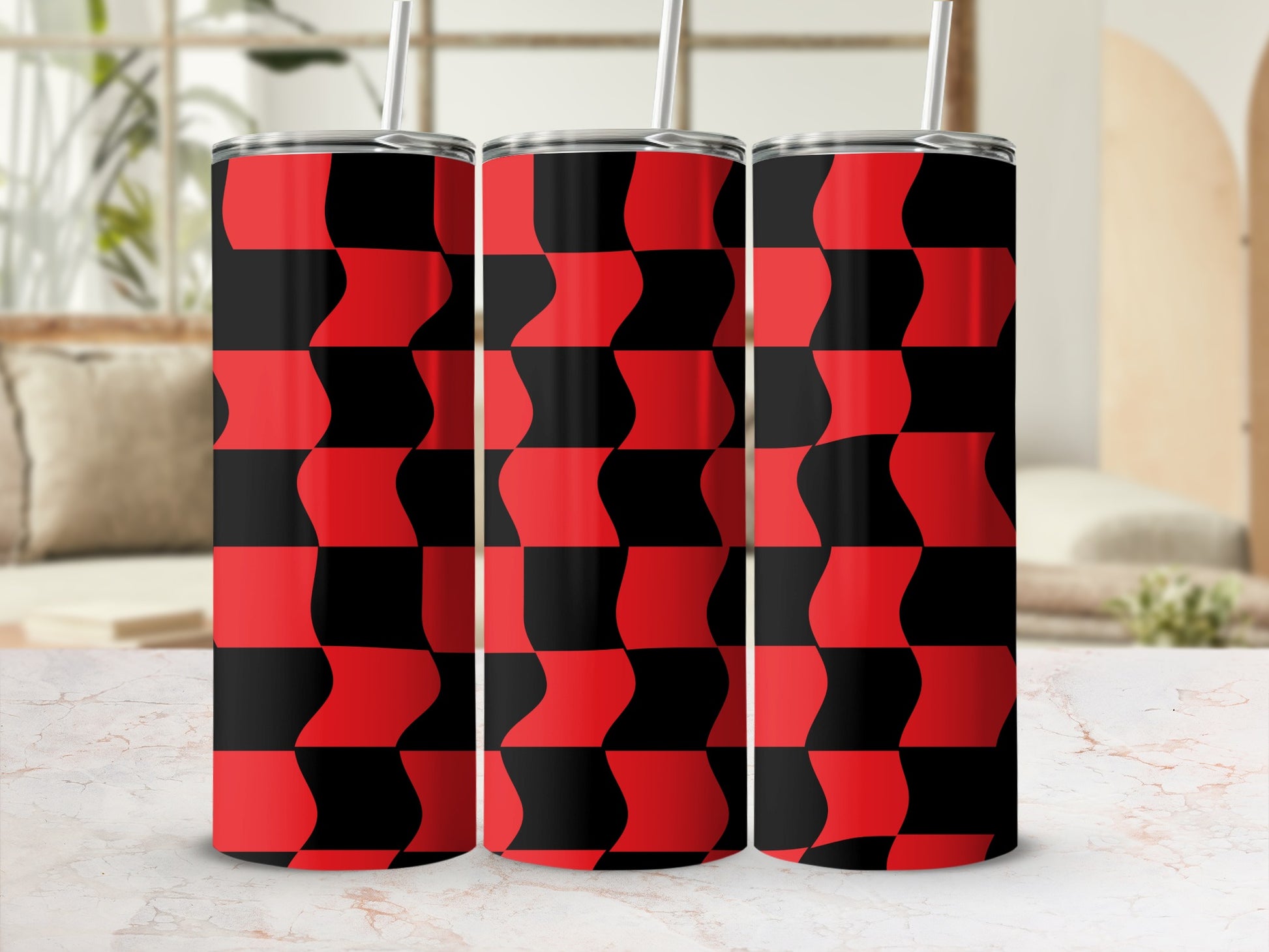 Three red and black checkered tumblers with straws on a marble surface.