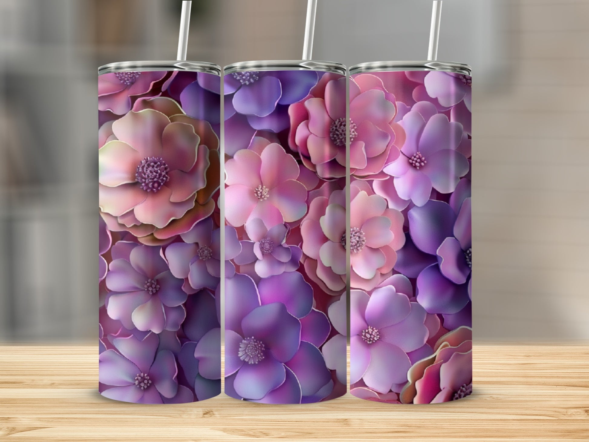 Three tumblers with a vibrant purple and pink floral design on a wooden surface.