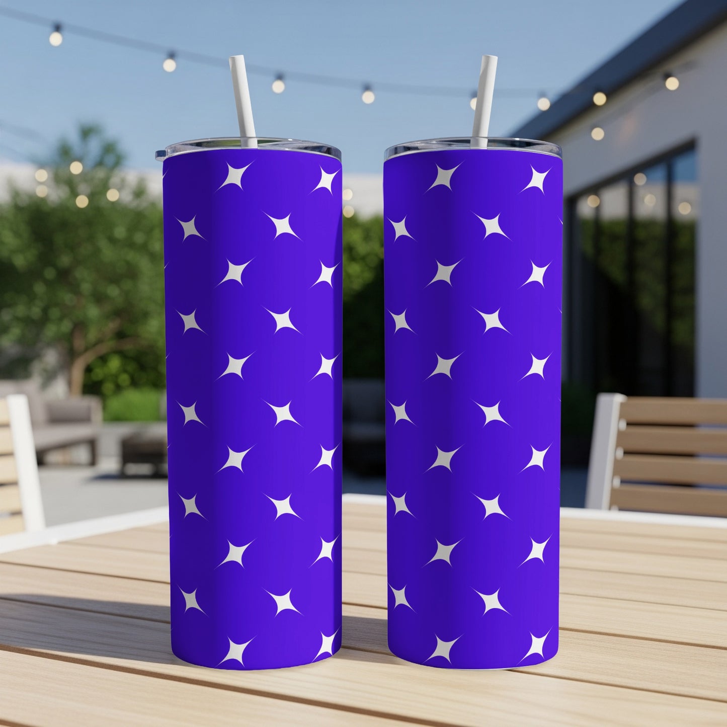 Two tall, blue tumblers with white star pattern, on a wooden table.