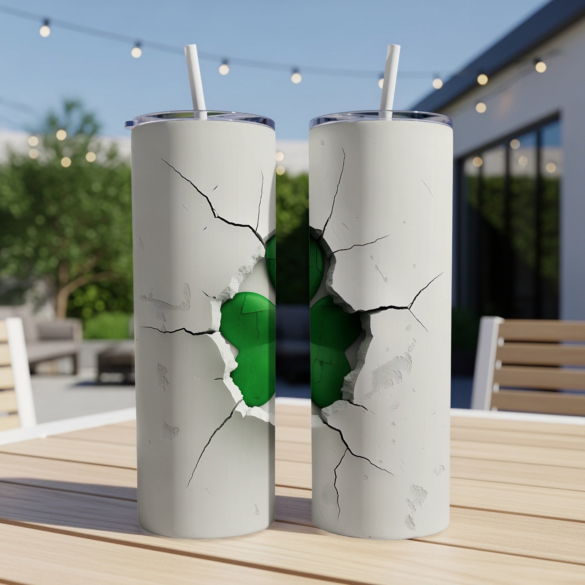 Two white tumblers with a green cracked design on a table.