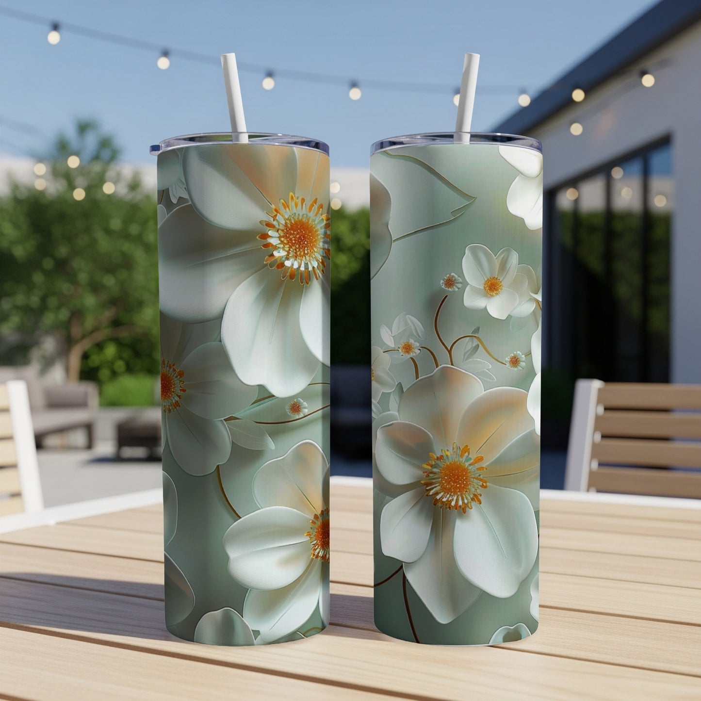 Two tumblers with white and orange floral pattern on wooden table.