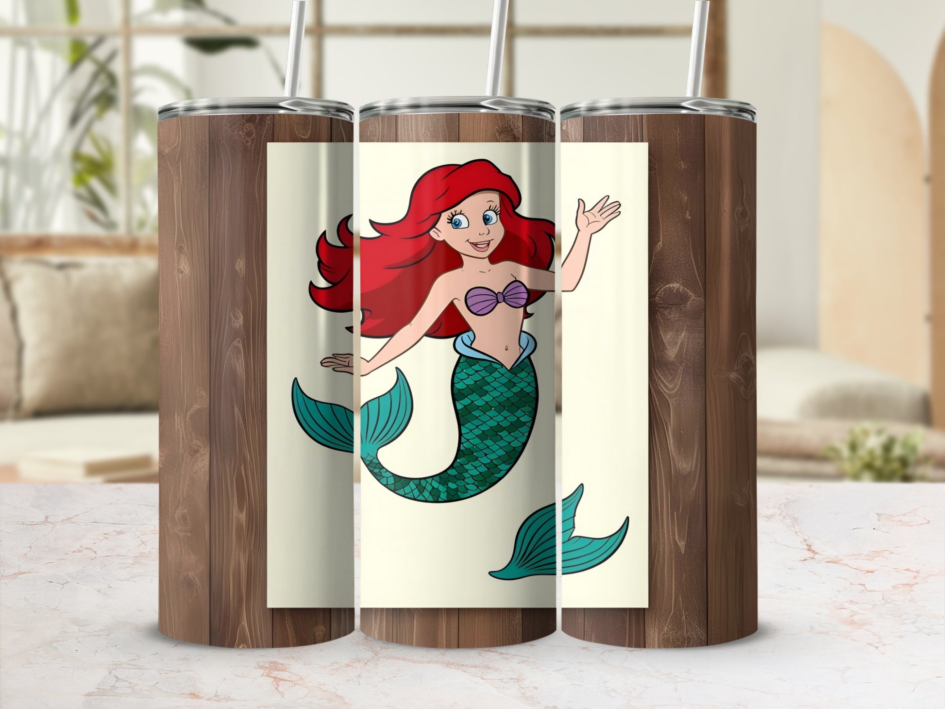 Ariel the mermaid with red hair and green tail on a tumbler.