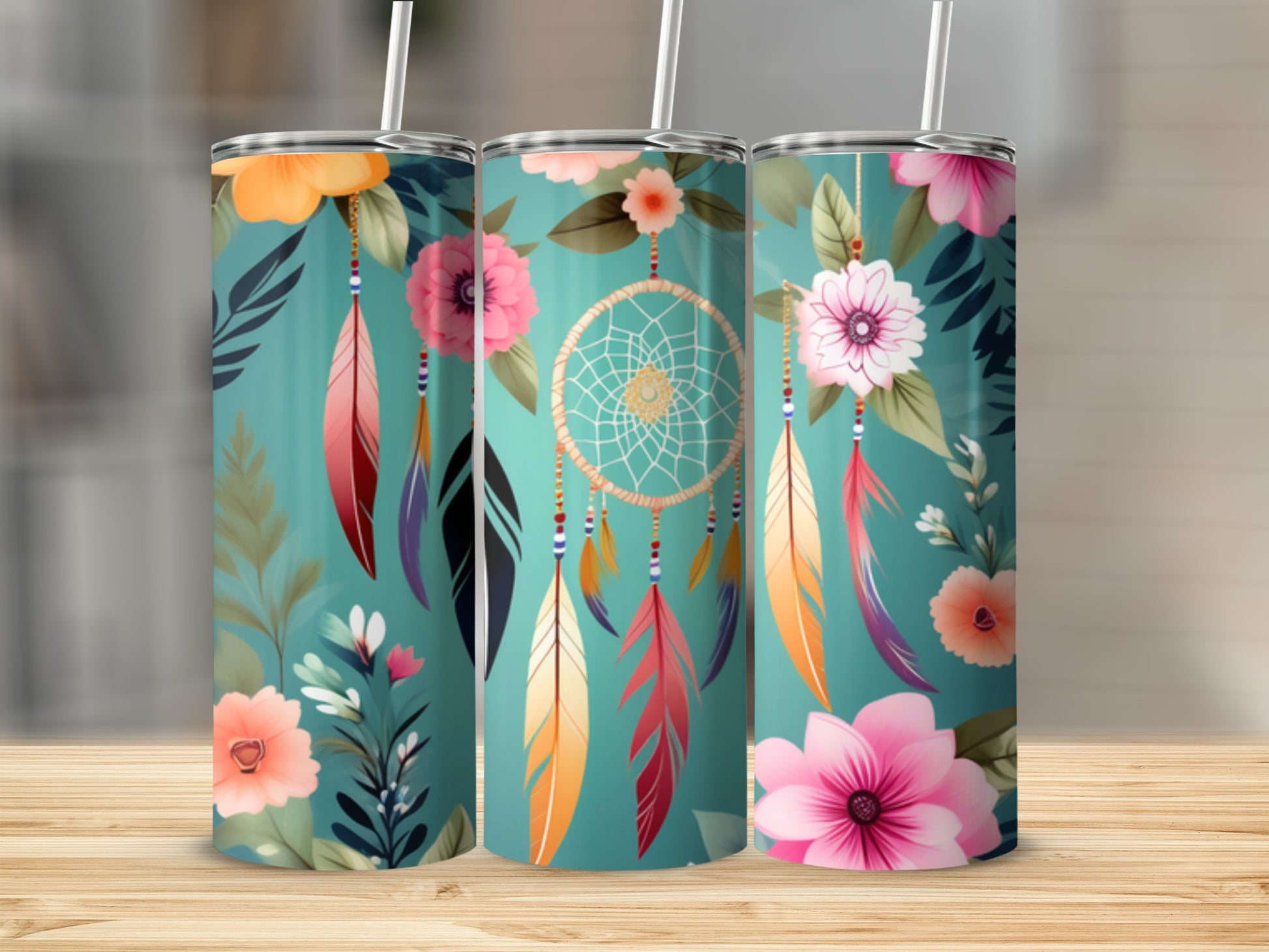 Three tumblers with floral and dreamcatcher designs stand side-by-side.