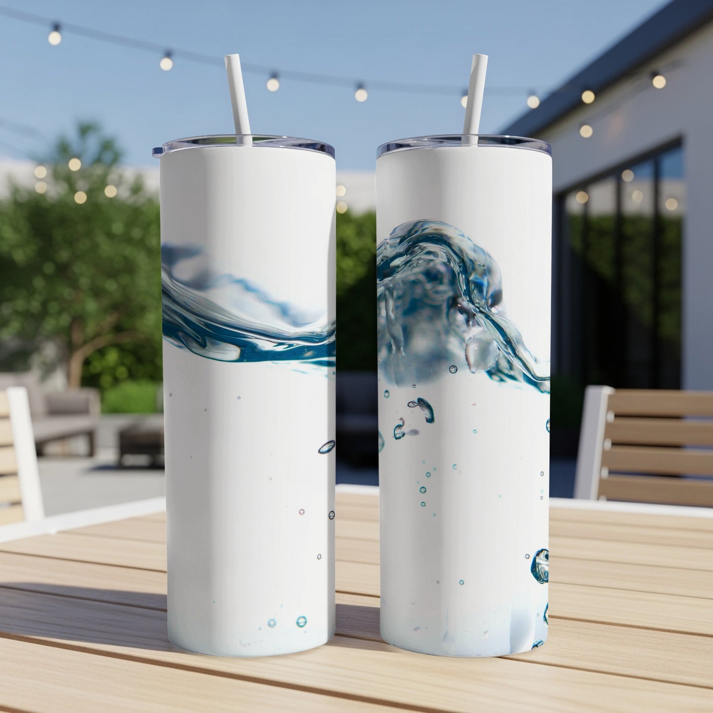 Two white tumblers with a splash of blue water and bubbles on a wooden table.