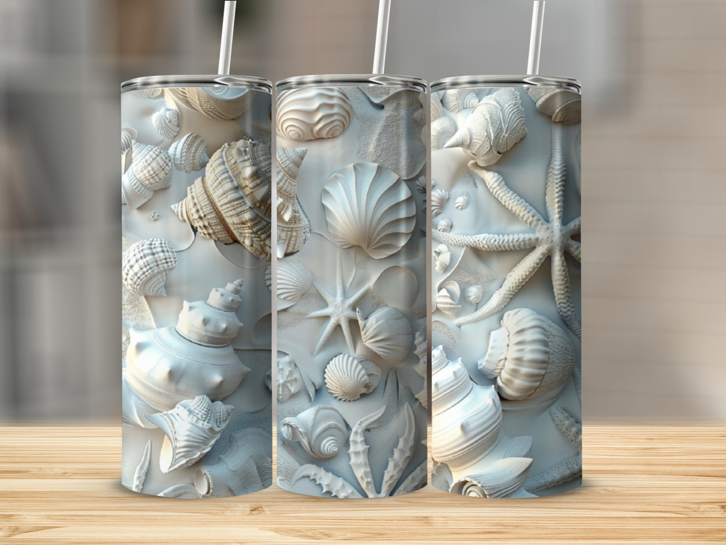 Three tall tumblers with embossed seashell and starfish patterns.