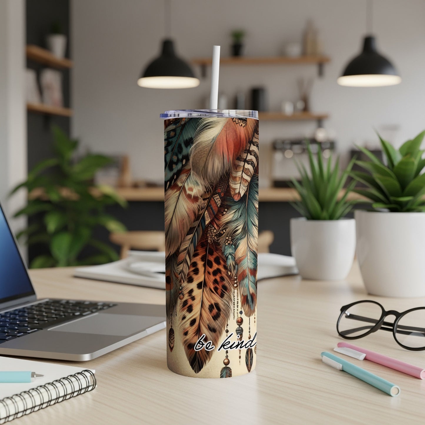 Tumbler with feather design and "be kind" text.