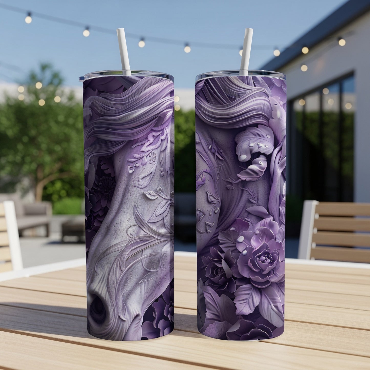 Two purple floral tumblers with straws on a wooden table outdoors.