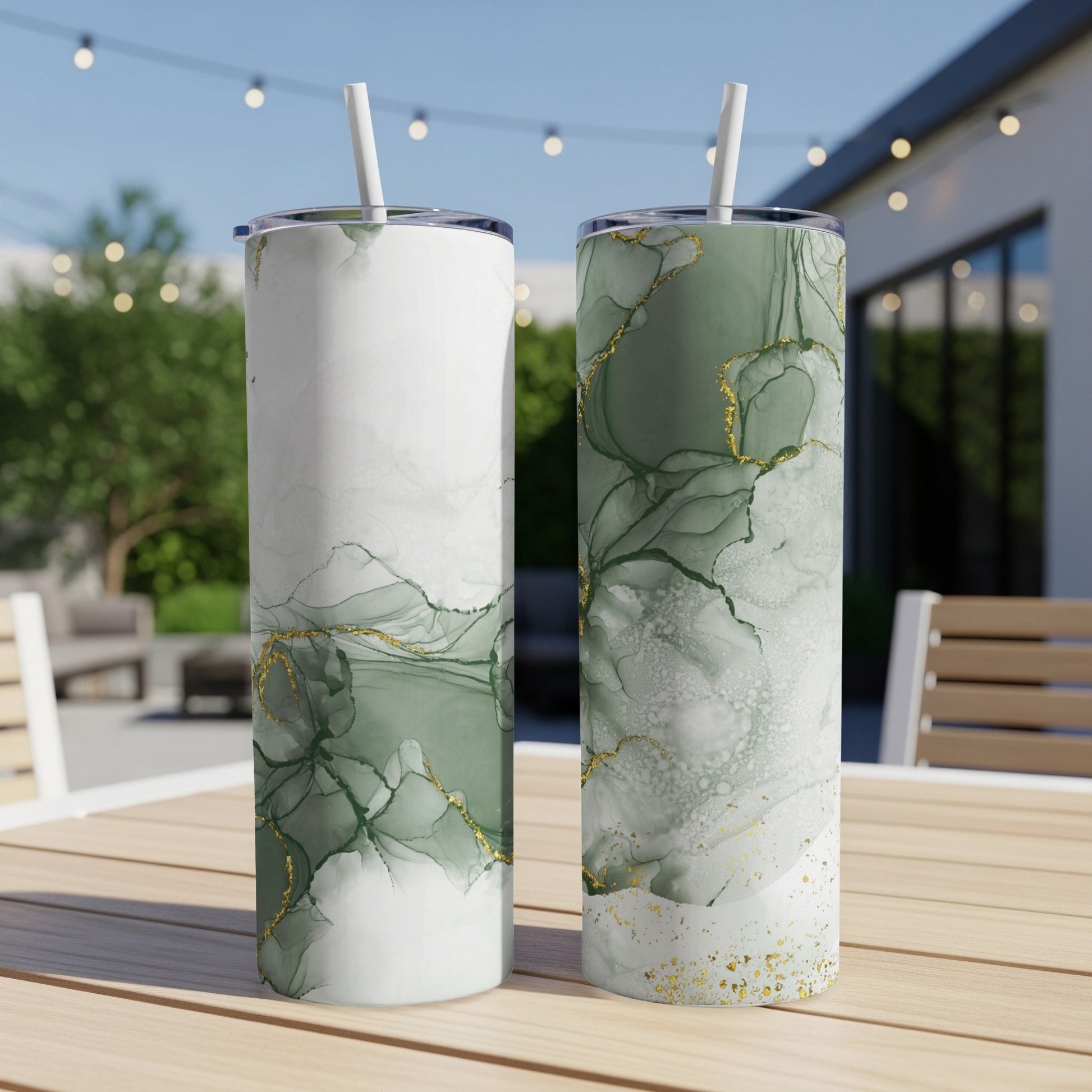Two green marble tumblers with gold accents on a wooden table.