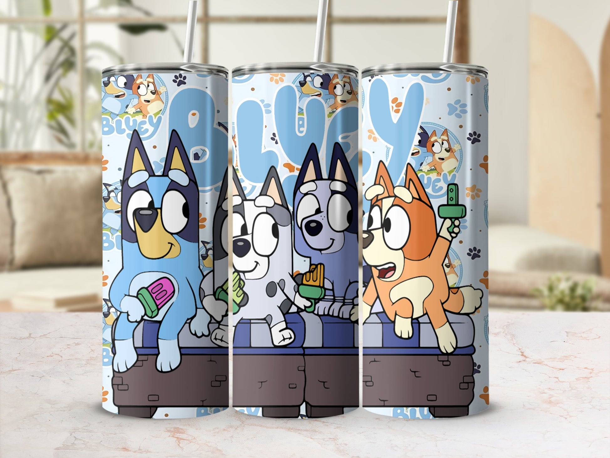 Bluey and Bingo characters on a blue patterned tumbler with straws.
