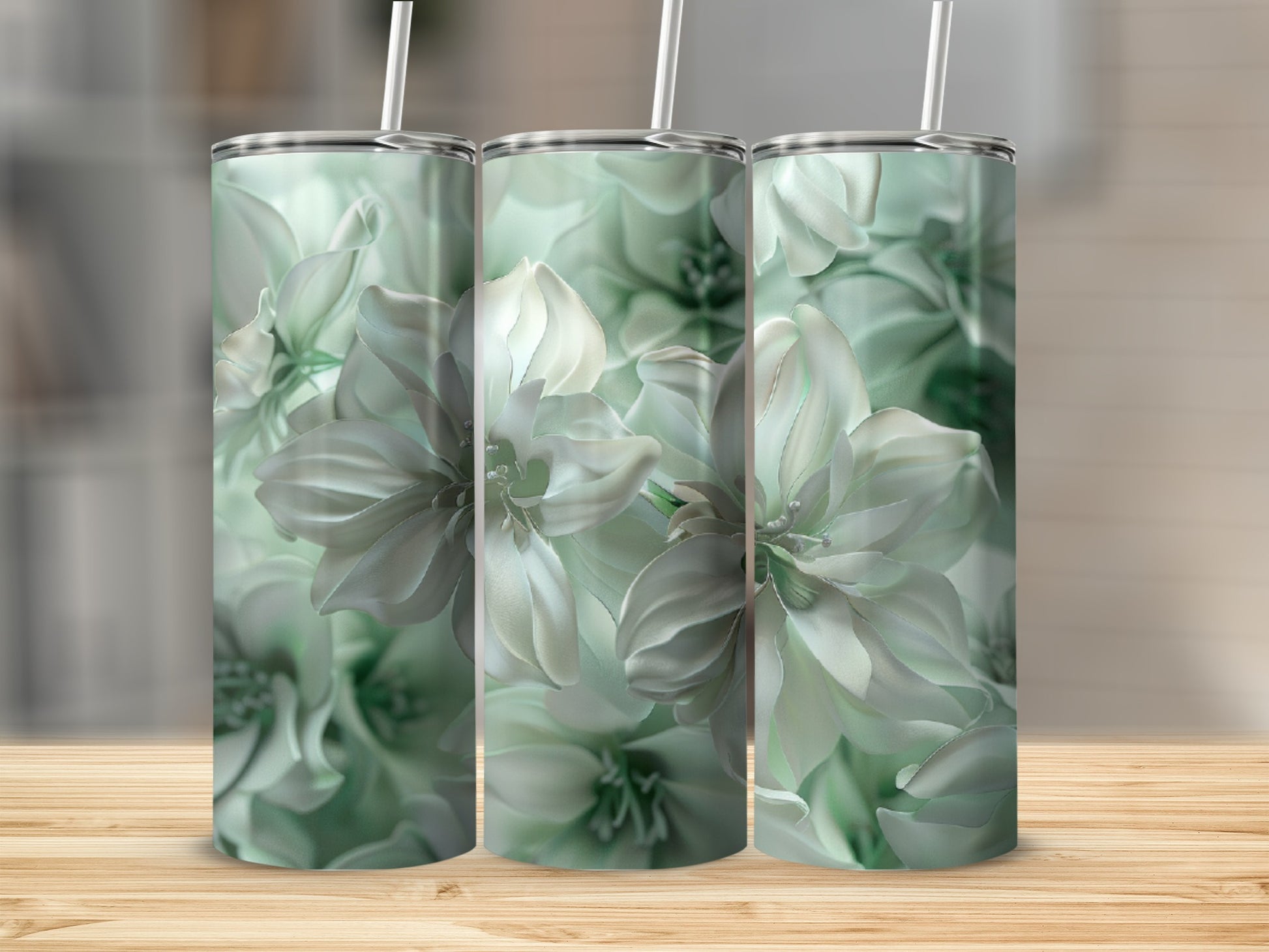 Three tumblers with a white floral design on a wooden surface.