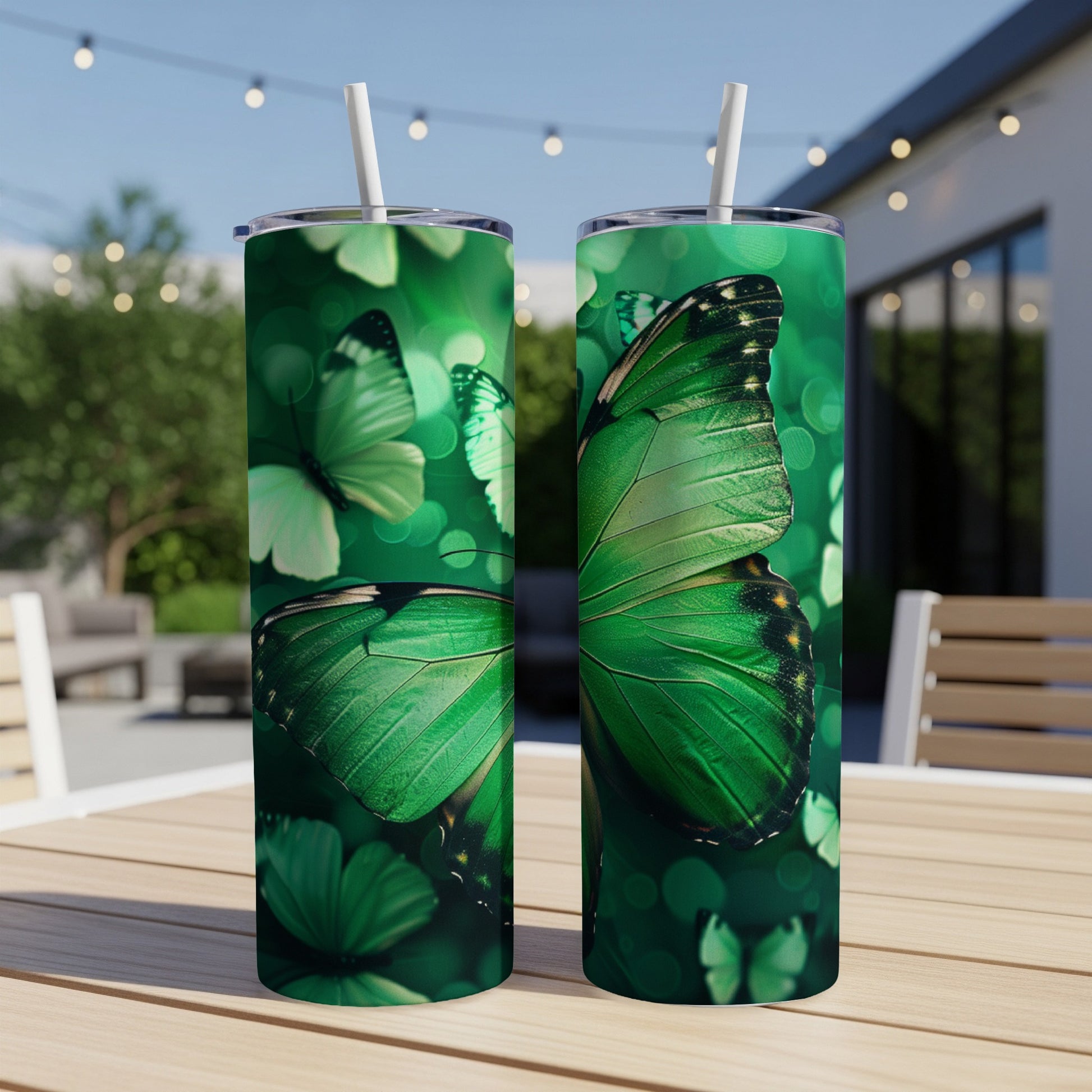 Two green butterfly tumblers on a table with a blurred outdoor background.