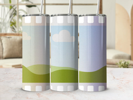 Three tumblers with pastel landscape and cloud designs.