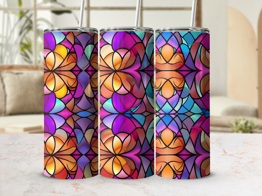 Three colorful stained-glass pattern tumblers with straws on a marble countertop.