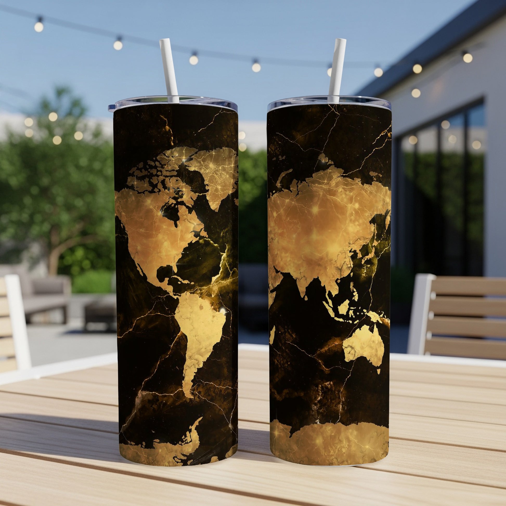 Two tumblers with a black and gold world map design, each with a white straw.