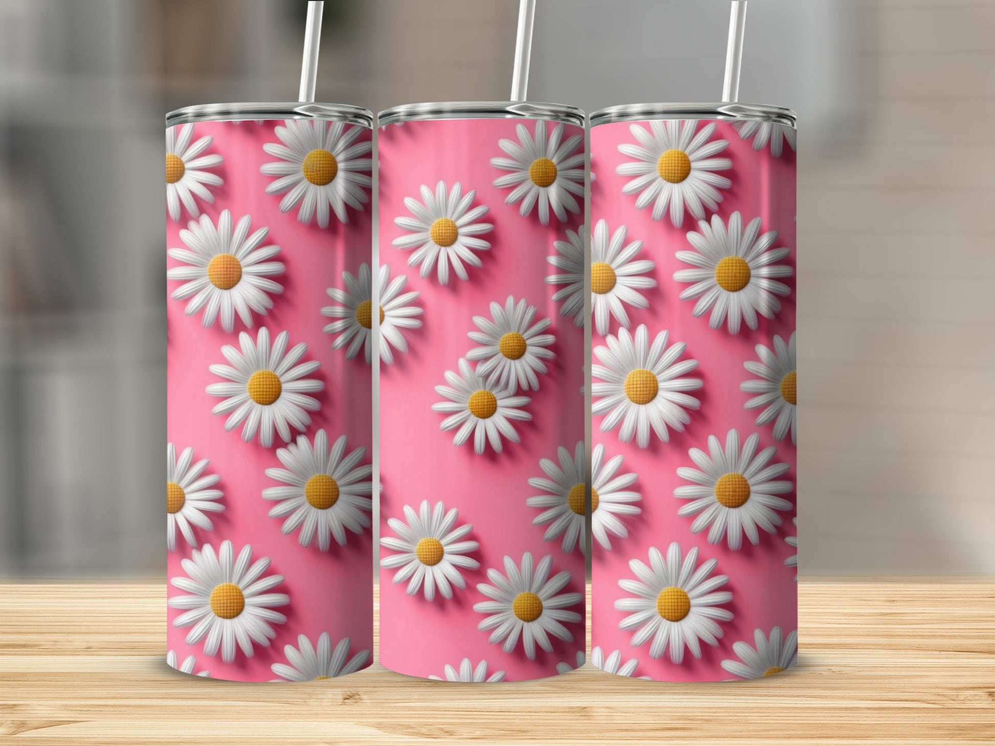 Three pink tumblers with white daisy pattern and straws.