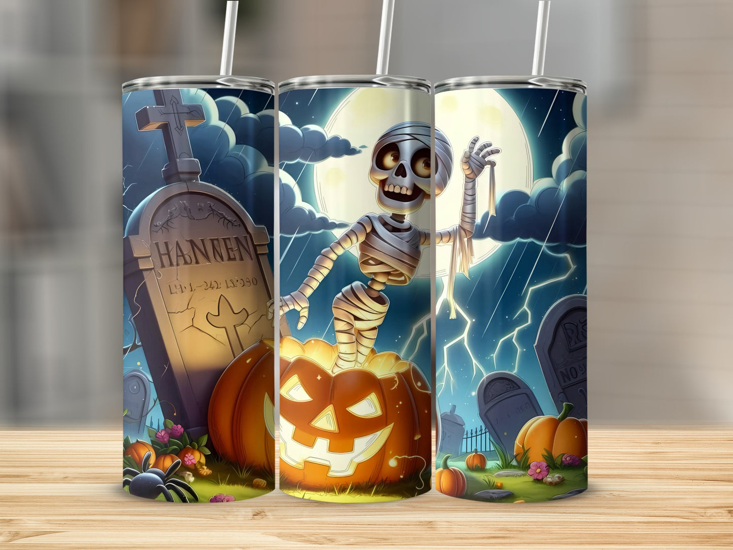 Halloween tumblers with a graveyard, skeleton, pumpkins, and a full moon.