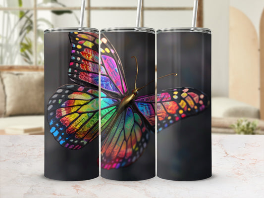Three tumblers displaying a colorful butterfly design on a marbled surface.