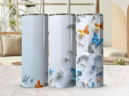 Three blank tumblers with butterfly designs on a marble surface.