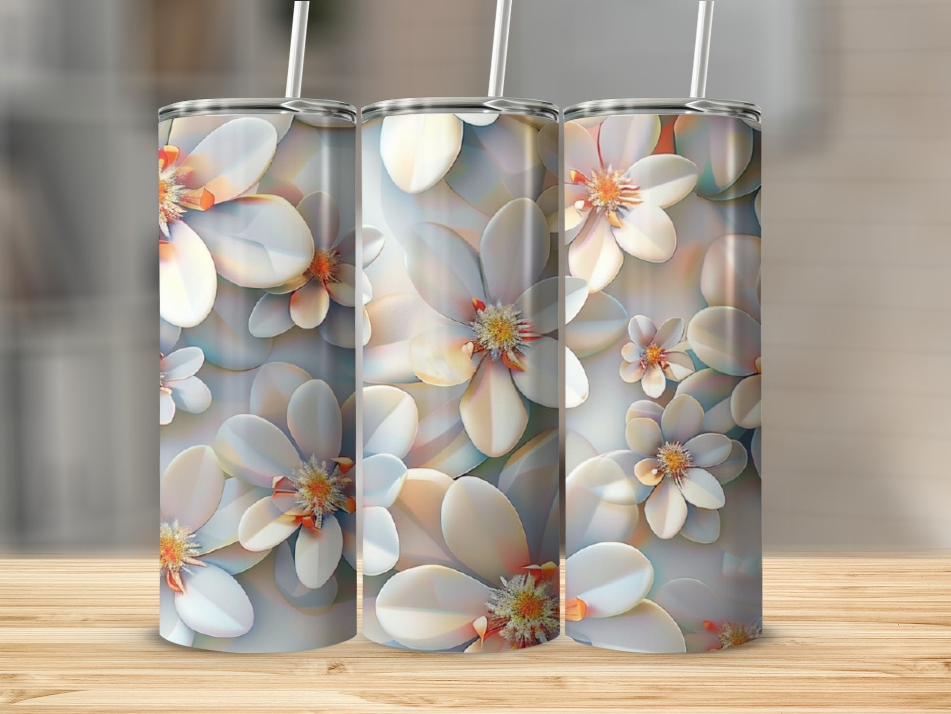 Three tumblers with white floral designs on a wooden surface.