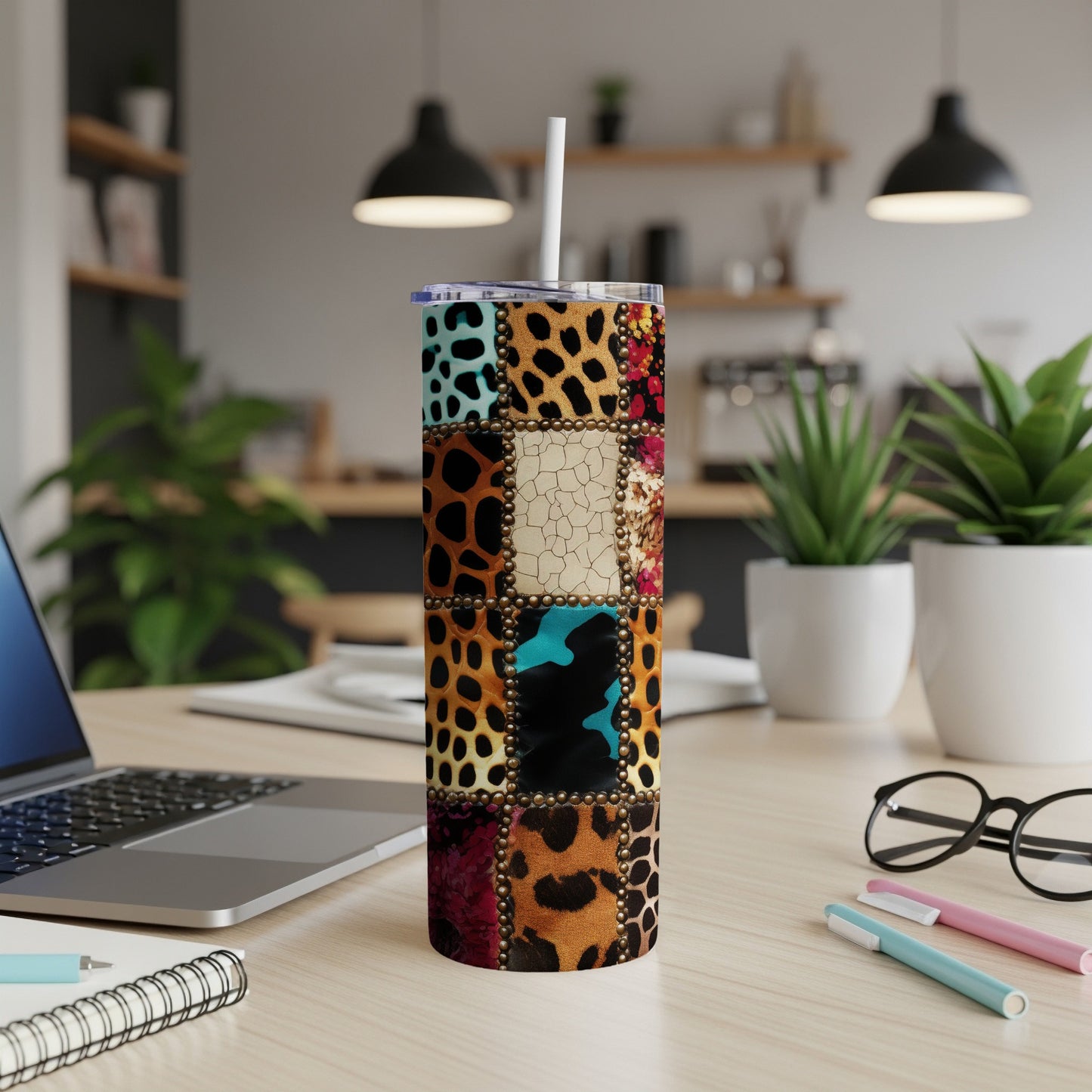Patchwork tumbler with animal print and textured square patterns, straw inserted.