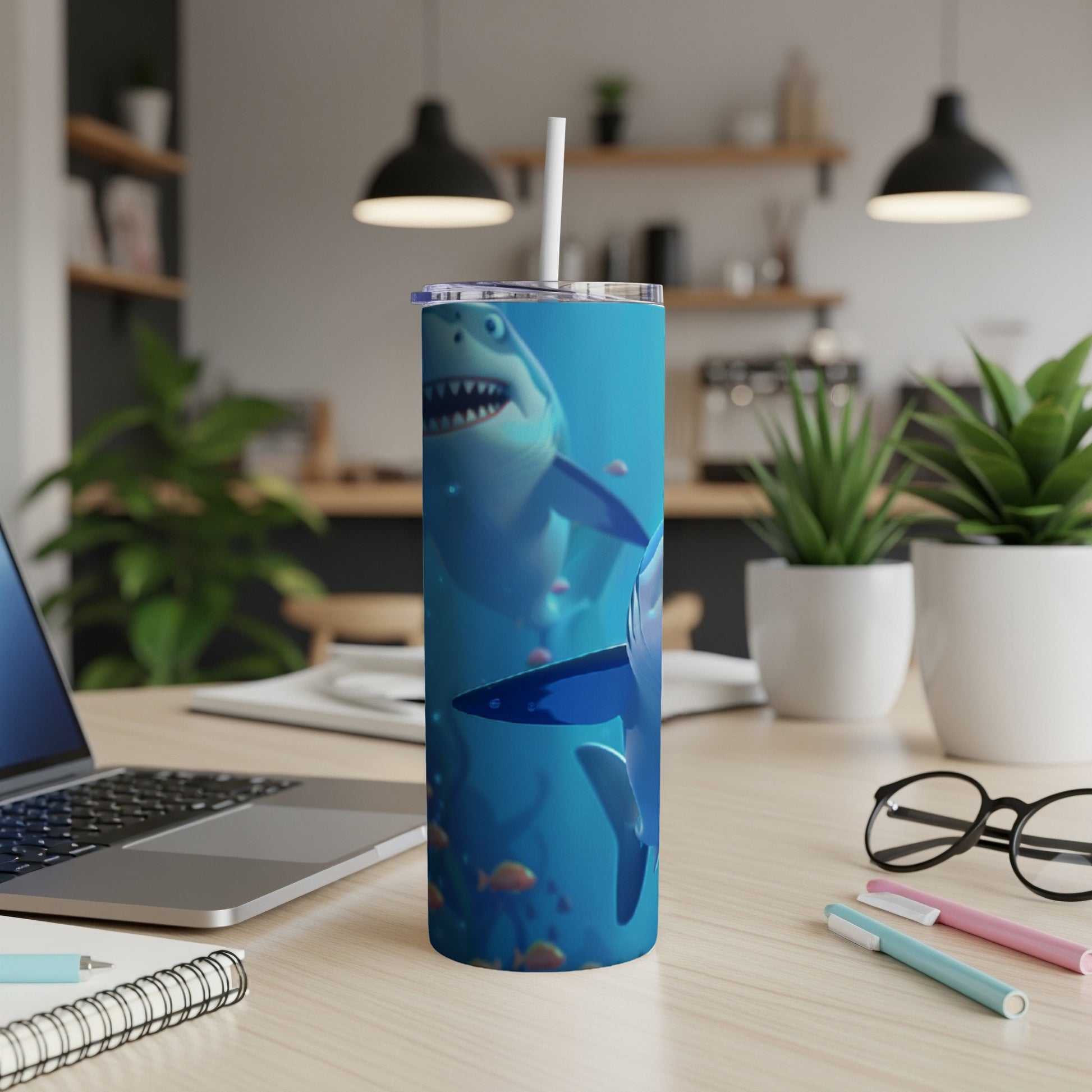 Cartoon sharks swim underwater on a blue tumbler with a straw.
