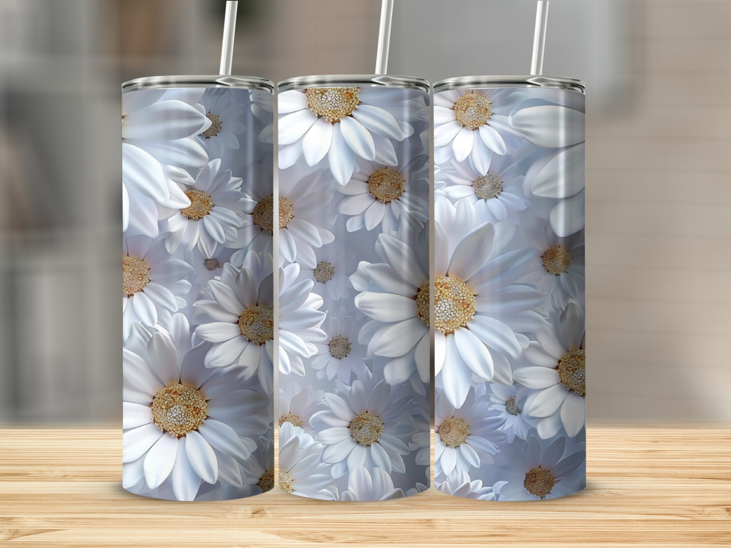 Three tumblers with white daisy floral pattern on a wooden surface.
