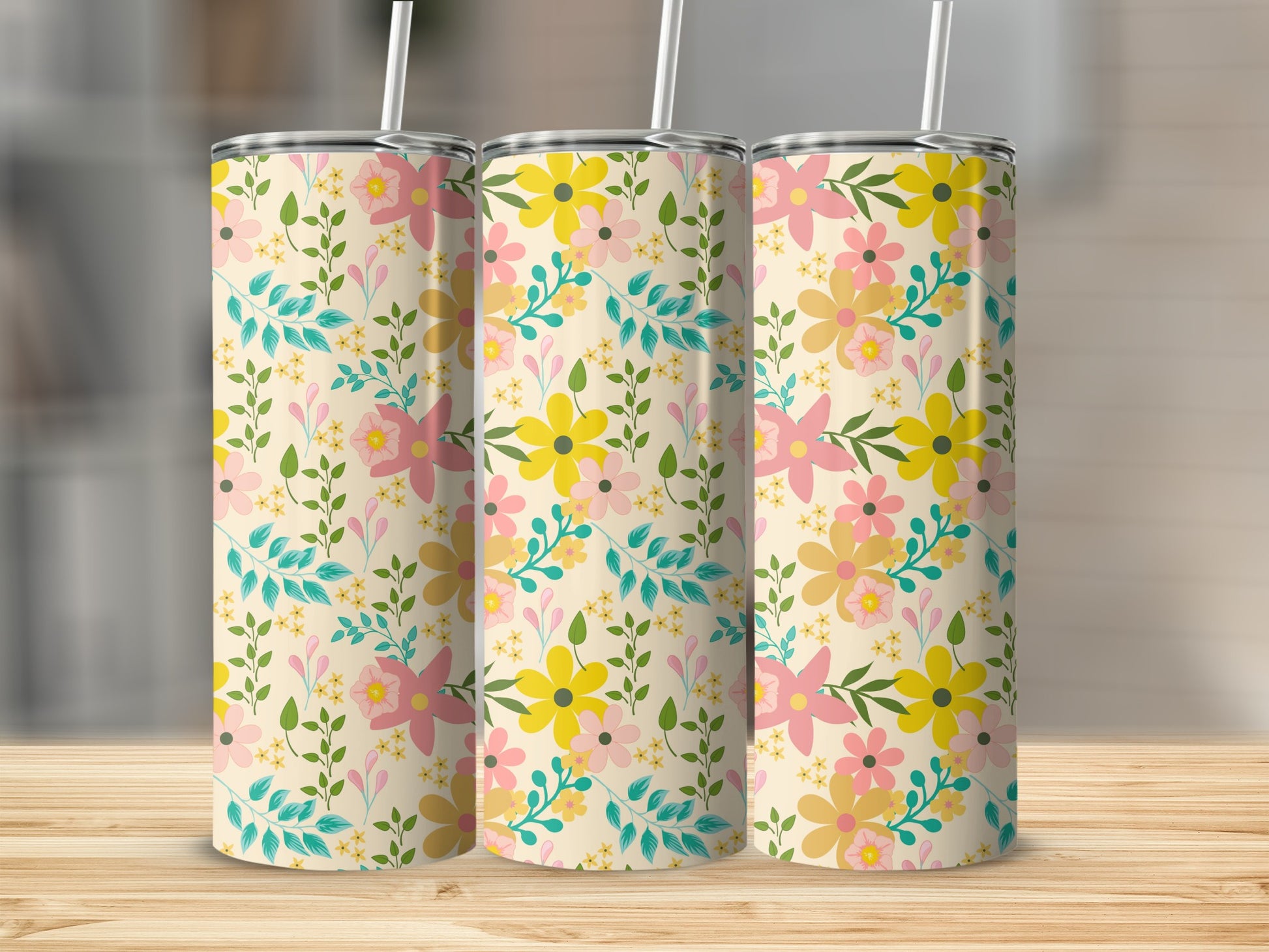 Three tumblers with a cream background and a scattered floral pattern of pink and yellow flowers.