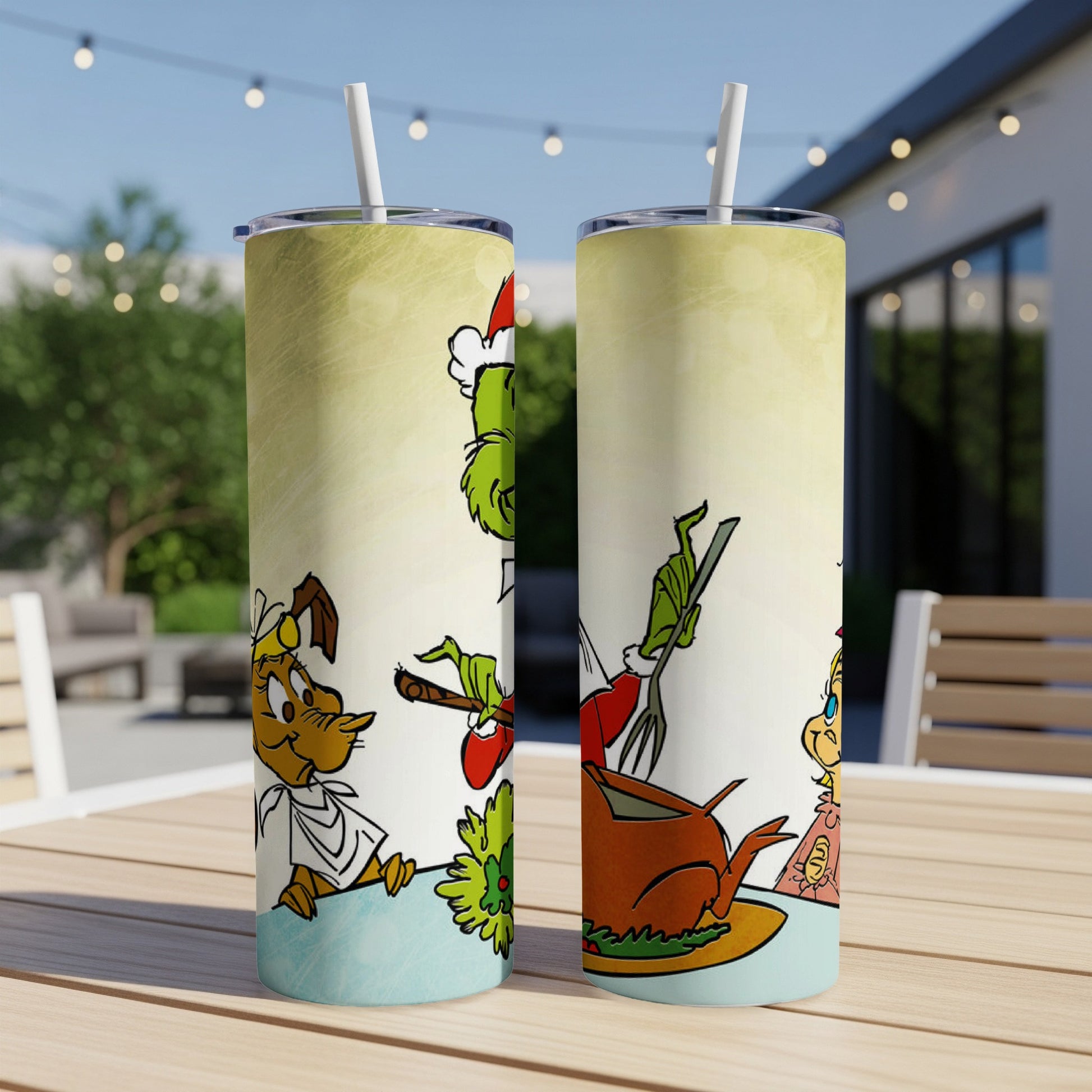 Two Grinch-themed tumblers with Christmas imagery on an outdoor table.