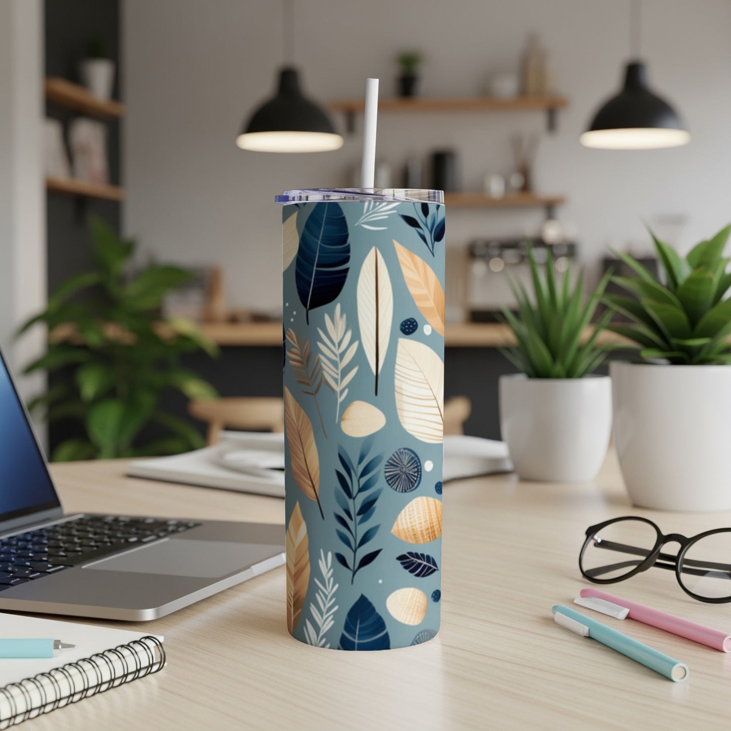 Tall insulated tumbler with blue and tan leaf and feather pattern.