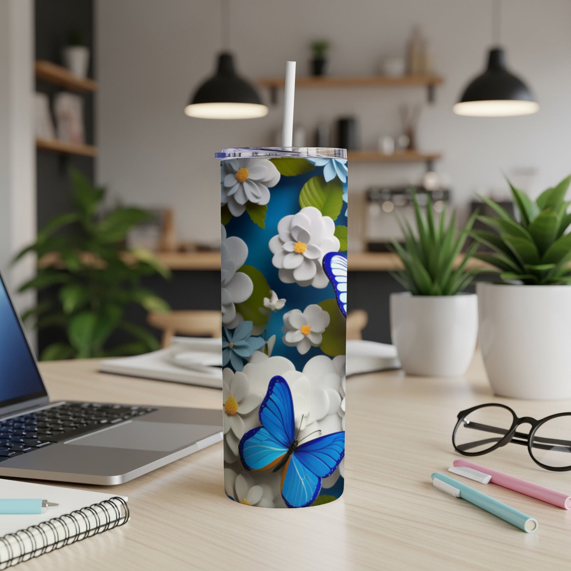 Blue butterfly and floral pattern on a white tumbler with straw.