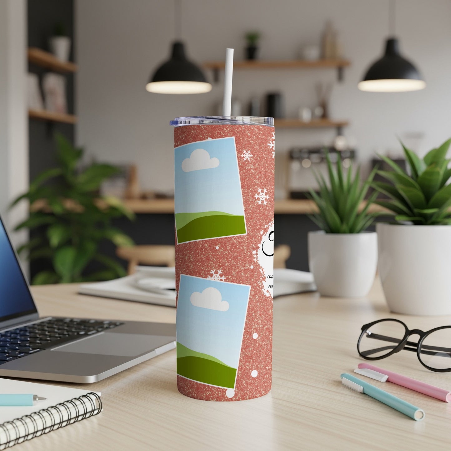 Glittery pink tumbler with photo frames, snowflakes, and text on a desk.