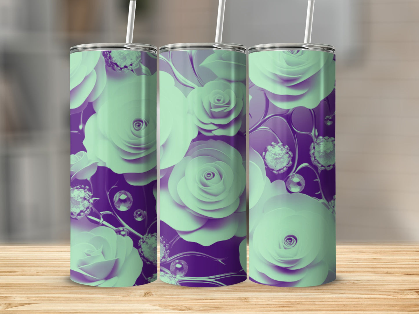 Three mint green and purple floral tumblers with straws on a wooden surface.