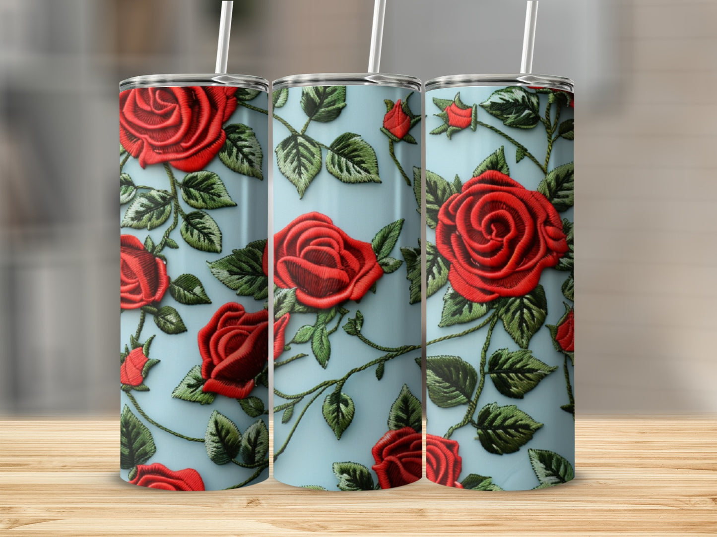 Three tumblers with red rose embroidery pattern on a light blue background.