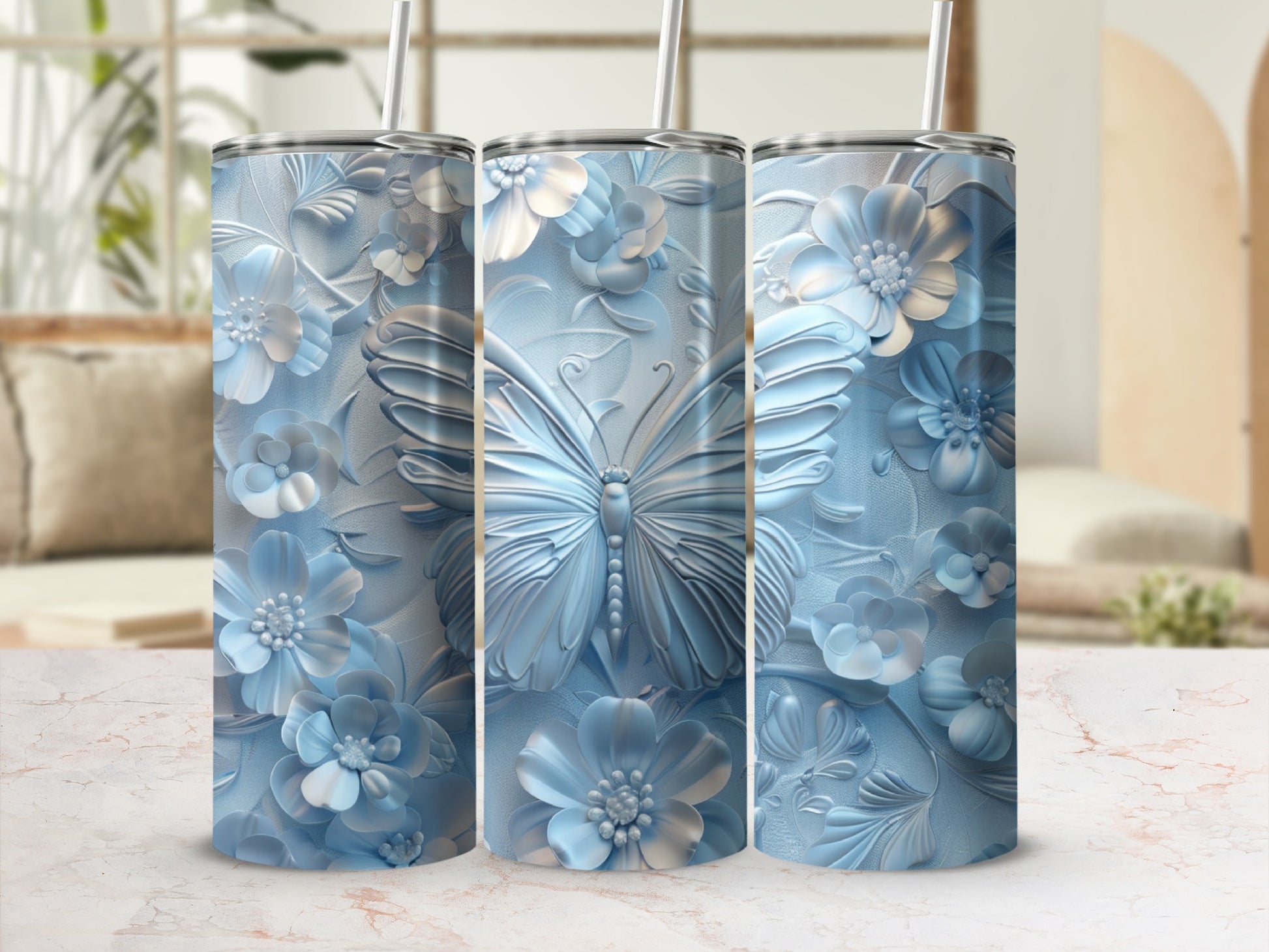Three blue floral tumblers with embossed butterfly design and reusable straws.
