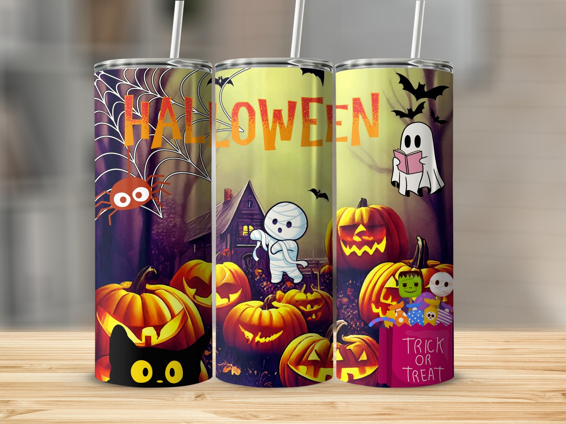 Three tumblers with Halloween designs: spiderweb, ghost, mummy, and pumpkins.