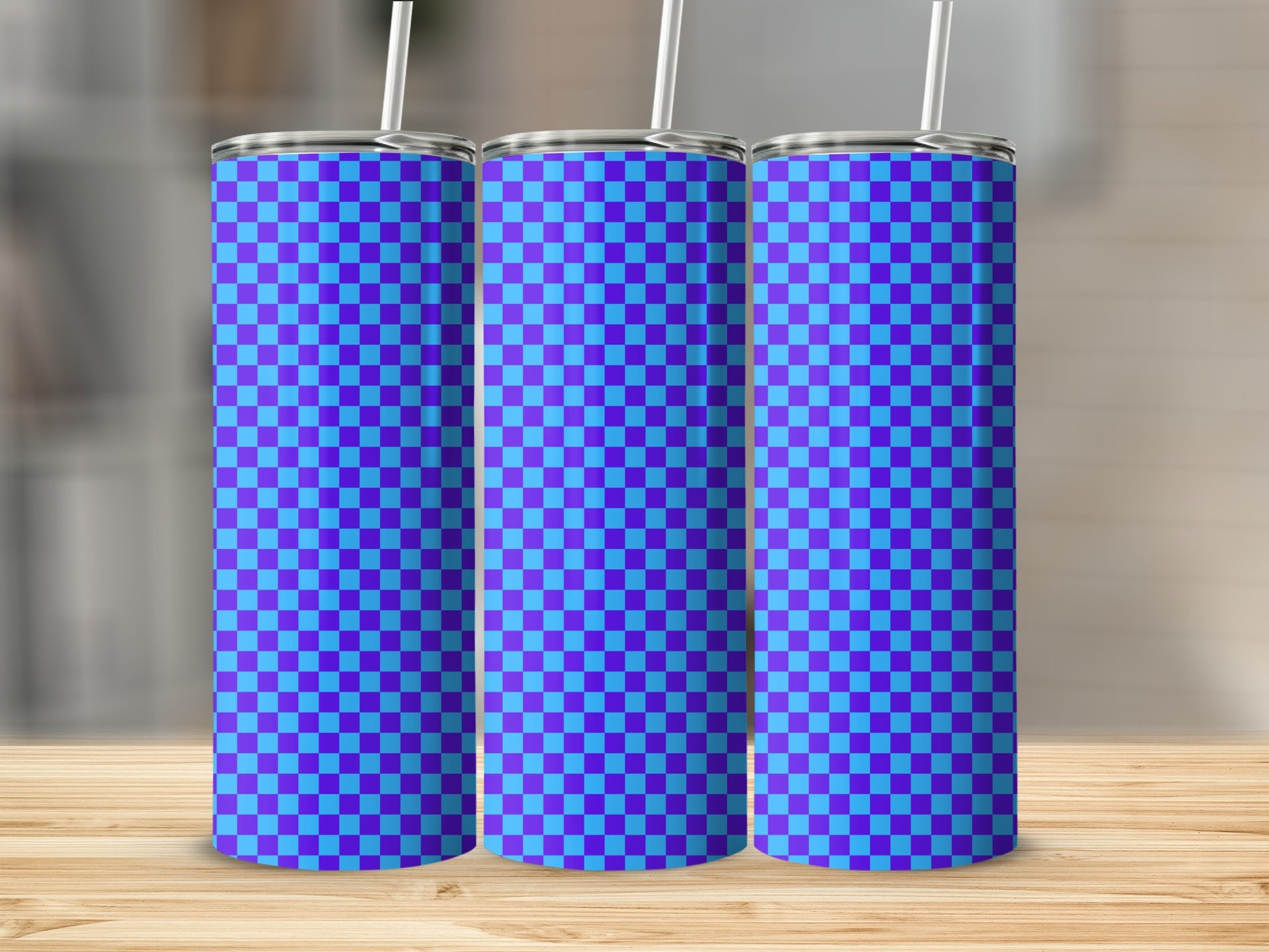 Three tumblers with a blue and purple checkered pattern stand on a wooden surface.