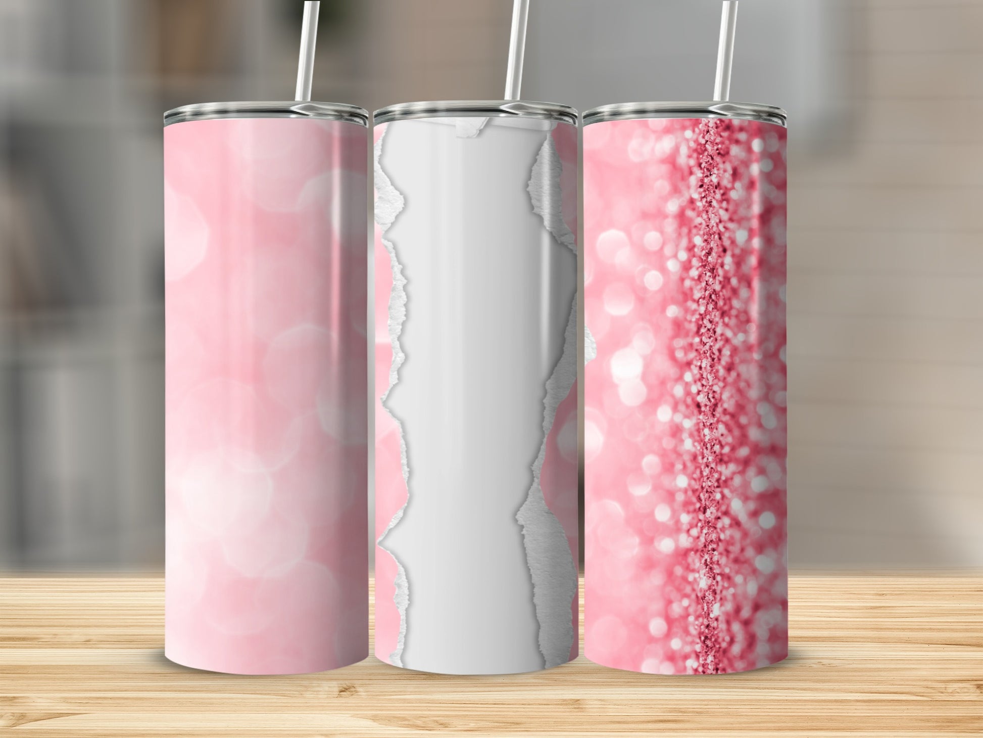 Three pink glitter tumblers with straws on a wooden surface.