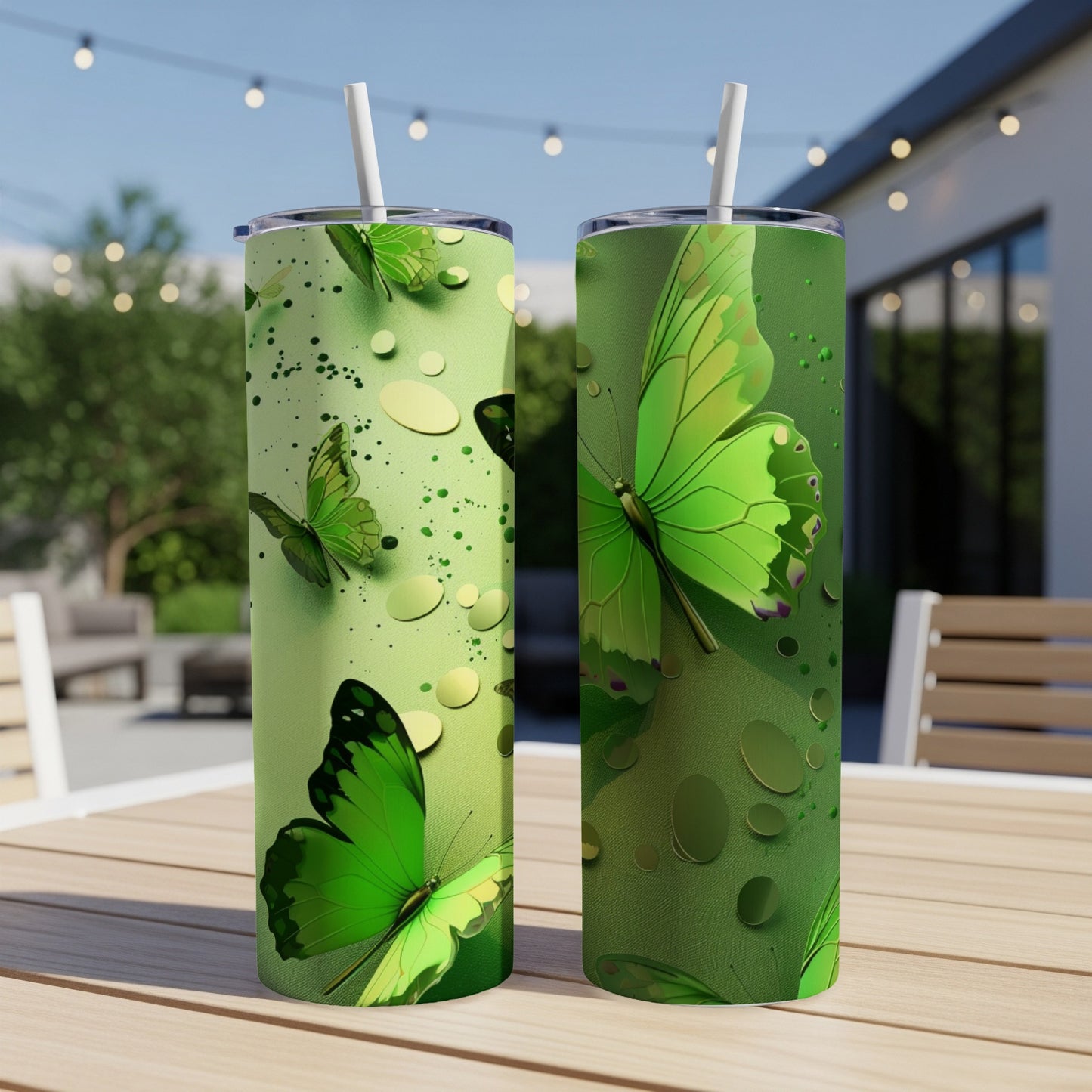 Two green tumblers with butterfly and water droplet designs on an outdoor table.