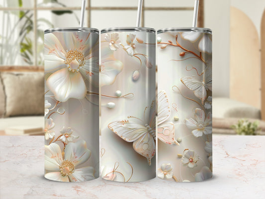 Floral and butterfly design on three white tumblers with straws.
