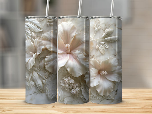 Three tumblers with embossed pale pink hibiscus flowers on a marble background.