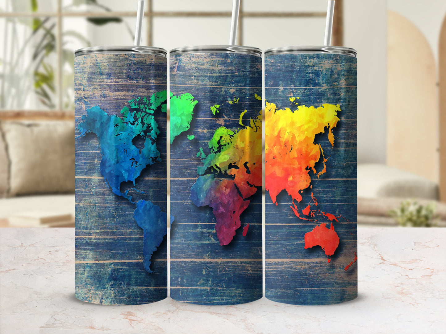 Three tumblers with colorful world maps against a distressed blue wood background.