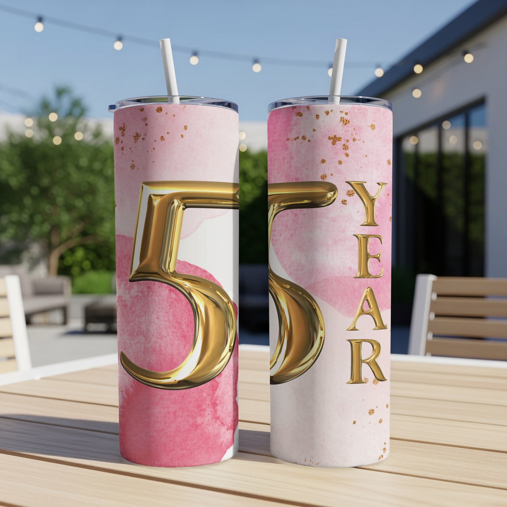 Gold 55 and "YEAR" text on a pink watercolor tumbler with gold flecks.